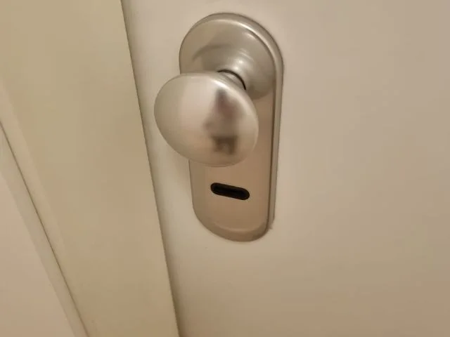 Cerradura con pomo metálico sobre puerta blanca, ilustrando el servicio de apertura de puertas con tarifas diferenciadas en Navalcarnero