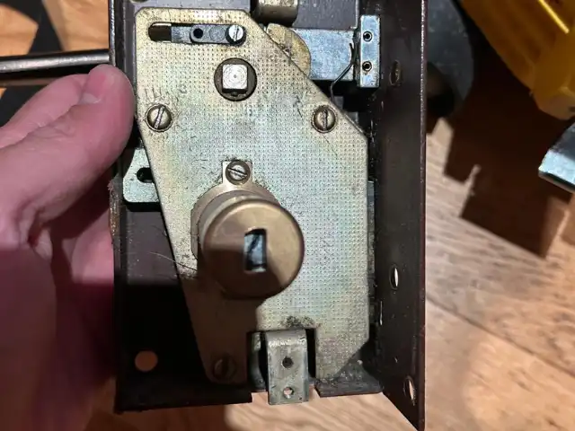 Mano instalando una cerradura en una puerta como parte del servicio profesional de cerrajería de Jumaser
