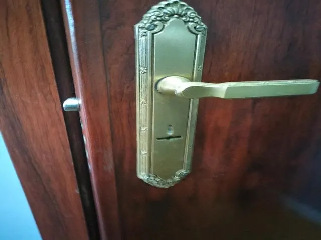 Vista frontal de una manilla decorativa con cerradura de gorjas antes de la conversión a perfil europeo
